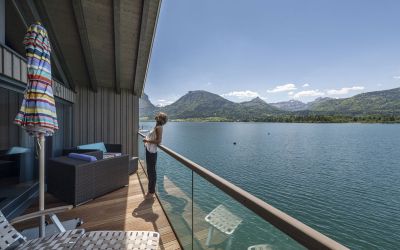Frau genießt auf Balkon Seeblick der Bootshaus Suite des Designhotels Cortisen am Wolfgangsee