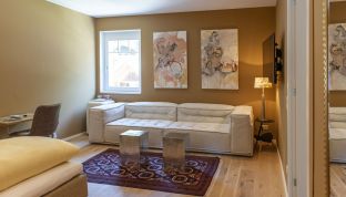 Sofa und Gemälde im Deluxe Zimmer mit Bergblick im Designhotel Cortisen am Wolfgangsee
