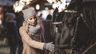 Frau streichelt Pferd in Pferdekutsche beim Wolfgangseer Advent