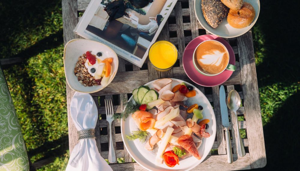 gedeckter Frühstückstisch im Garten des Boutique Hotels Cortisen am Wolfgangsee