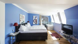 Schlafzimmer mit Doppelbett in der Loft Suite mit Seeblick im Bouqtiuehotel Cortisen am Wolfgangsee