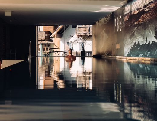 Mann schwimmt im Infinity-Pool im Wellnesshotel für Erwachsene am Wolfgangsee